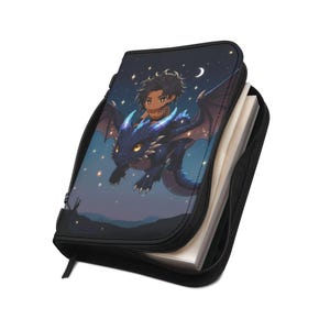 Könnte beinhalten: Schwarzer Reißverschlussordner mit Fantasy-Illustration. Das Bild zeigt eine Person, die auf einem blauen Drachen durch einen Sternenhimmel reitet. Der Ordner ist geöffnet und zeigt weiße Seiten.