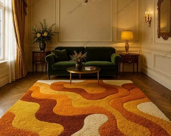 May include: A retro-style area rug with a wavy pattern in shades of orange, yellow, and cream. The shag rug is placed in a living room with a green sofa, a coffee table, and a chandelier. The rug measures approximately 8 x 10 feet.