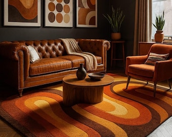 Może przedstawiać: Salon w stylu retro z brązową skórzaną sofą Chesterfield, pomarańczowym fotelem i okrągłym drewnianym stolikiem kawowym. Pokój jest ozdobiony abstrakcyjną sztuką i dywanem z odważnym, zakrzywionym wzorem w odcieniach pomarańczu i brązu.