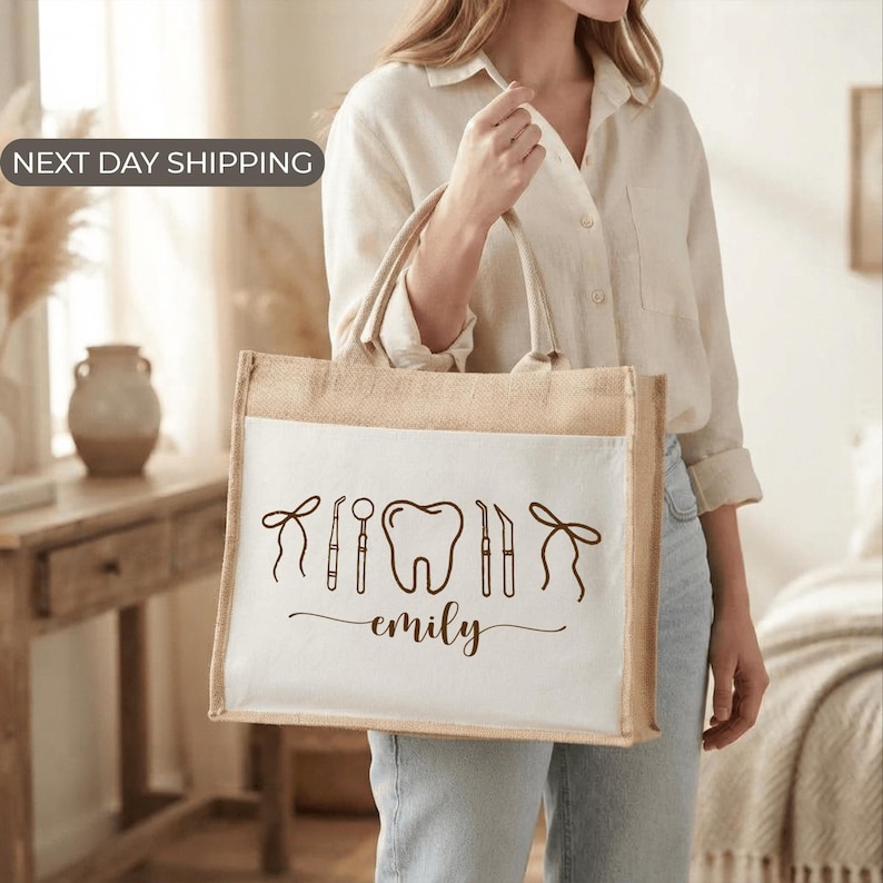 A woman is holding a large tote bag with a dental-themed design printed on it.