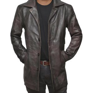 May include: A dark brown leather jacket with a collared neckline and button closure. The jacket has two front pockets and a brown belt. The leather has a distressed appearance.