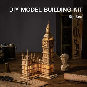 May include: DIY Model Building Kit of Big Ben. A detailed wooden model of the iconic clock tower, illuminated from within. The model is made of light-colored wood and features intricate architectural details. The image also includes a vintage camera and a small bust.