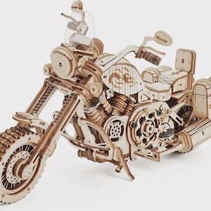 Peut inclure: Maquette en bois détaillée d'une moto, avec des engrenages complexes, une roue avant et une selle. Le modèle est en bois brun clair et présente un design de moto classique. Le modèle mesure environ 30 cm de long.