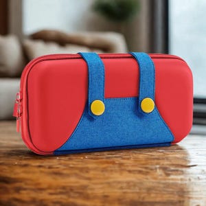 Peut inclure: Une trousse rouge et bleue à fermeture éclair, rappelant une salopette de personnage de jeu vidéo. La trousse a un corps rouge, des bretelles et une bavette bleues, et des détails de boutons jaunes. Elle est posée sur une surface en bois.