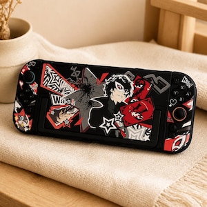 May include: A black handheld gaming console case featuring a graphic design with a character wearing a white mask, red and white star motifs, and the text Wake Up. The case includes integrated controller grips with black buttons and joysticks.