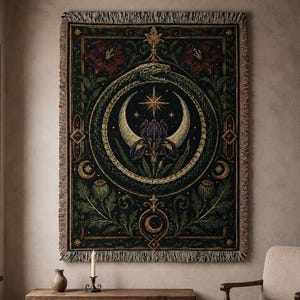 Puede incluir: Un tapiz rectangular verde oscuro con un diseño detallado que presenta una serpiente, medias lunas, una estrella y elementos florales. El tapiz tiene un borde con flecos y está colgado en una pared. La paleta de colores incluye verde, dorado, rojo y morado.