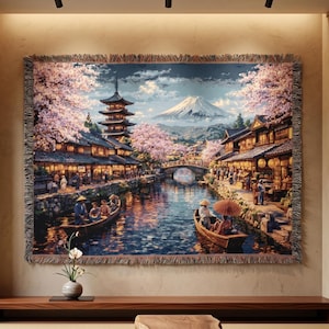 Könnte beinhalten: Ein gewebtes Wandteppich, das eine japanische Landschaft mit einem Fluss, Booten und Gebäuden zeigt. Die Szene umfasst eine Pagode, Kirschblüten und einen Berg im Hintergrund. Der Wandteppich wird in einem Raum mit einem großen Fenster und einer Holzbank ausgestellt.