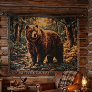 May include: A rustic cabin interior featuring a large tapestry depicting a brown bear in a forest setting. The room includes a leather armchair with a plaid blanket, a wooden side table, and a cozy rug. A window offers a view of a snowy landscape.