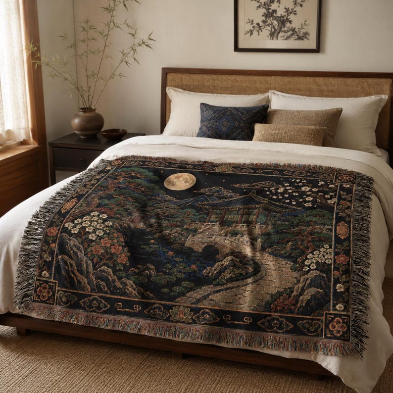 Korean palace tapestry wall hanging on a white background, showing a moonlit traditional garden with tiled pavilion, stone bridge, pond, pine tree, white blossoms, mountains, woven texture, and fringed edges.