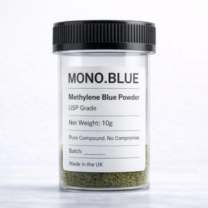 Puede incluir: Un frasco de vidrio transparente con tapa negra, que contiene un polvo verde. La etiqueta dice "MONO.BLUE Methylene Blue Powder USP Grade Peso neto: 10g". También se ve el texto "Pure Compound. No Compromise.". Hecho en el Reino Unido.