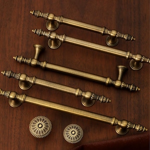 May include: A white ceramic mug with a black handle and the text "But First, Coffee" in a handwritten style. The mug is on a white surface. The mug is approximately 10 cm tall.