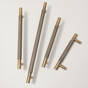 May include: Four brass cabinet pulls with a textured, brown finish. The pulls vary in length and design, with cylindrical and T-bar shapes. These decorative hardware pieces are ideal for updating kitchen or bathroom cabinets.