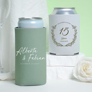 May include: A white ceramic mug with a black handle and the text "But First, Coffee" in a bold, black font. The mug is set against a blurred background, suggesting a cozy setting.