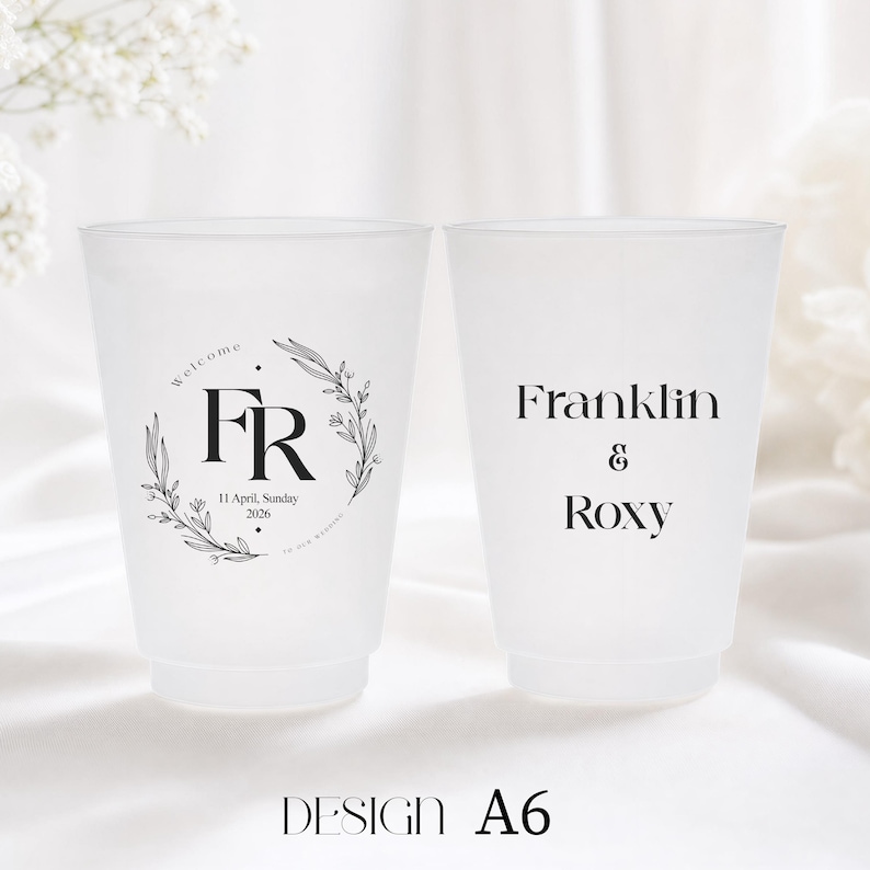 May include: Two frosted plastic cups with black text. One cup has the initials "FR" inside a floral wreath, with the date "11 April, Sunday 2026". The other cup has the names "Franklin & Roxy". The design is labeled "A6".