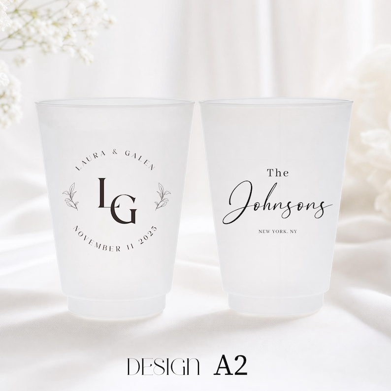 May include: Two frosted plastic cups with custom wedding details. One cup features the initials "LG" with "LAURA & GALEN" and "NOVEMBER 11 2025". The other cup says "The Johnsons" and "NEW YORK, NY". The design is labeled "DESIGN A2".