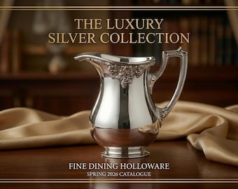 May include: A silver pitcher with ornate detailing, part of "The Luxury Silver Collection." The pitcher has a curved spout and a decorative handle. The image also includes the text "Fine Dining Holloware" and "Spring 2026 Catalogue."