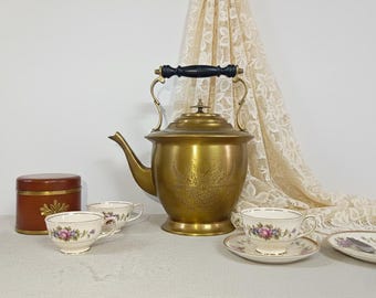 Tetera de latón vintage: tetera artesanal con grabado floral y mango de madera, ideal como decoración de cocina coleccionable.