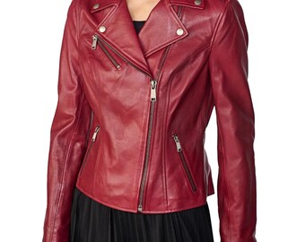 Pode incluir: Casaco de couro vermelho, estilo motociclista. Apresenta gola entalhada, fecho de correr assimétrico e vários bolsos com fecho. As mangas têm fechos nos punhos e detalhes metálicos prateados nos ombros.