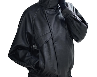 May include: Black leather jacket with a high collar, button closures, and two front pockets. The jacket has a ribbed hem and cuffs. The sleeves are slightly oversized. A stylish outerwear piece.