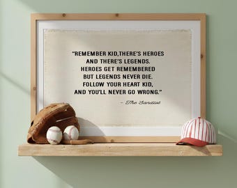 May include: A framed print featuring the quote: REMEMBER KID, THERE'S HEROES AND THERE'S LEGENDS. HEROES GET REMEMBERED BUT LEGENDS NEVER DIE. FOLLOW YOUR HEART KID, AND YOU'LL NEVER GO WRONG. - The Sandlot. A brown baseball glove and cap sit below.