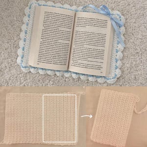 May include: An open book sits on a handmade, cream-coloured crochet book sleeve with a scalloped edge and light blue details. A light blue ribbon marks the page. The image also shows a close-up of the crochet texture.