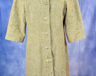 May include: A vintage olive green coat with a textured fabric. The coat features a unique collar, three-quarter sleeves, and a button-down front with six gold-colored buttons. The coat is displayed on a mannequin.