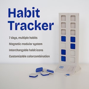 Puede incluir: Un rastreador de hábitos gris claro con fichas magnéticas azules y blancas. El texto "Habit Tracker" se muestra en azul. El texto adicional incluye "7 días, múltiples hábitos", "Sistema modular magnético", "Iconos de hábitos intercambiables".