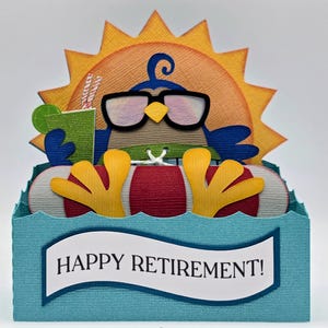 May include: A whimsical, layered papercraft card with a blue bird wearing sunglasses, relaxing in a red and white inner tube. The bird is holding a drink, with a sun in the background. The card reads "HAPPY RETIREMENT!"