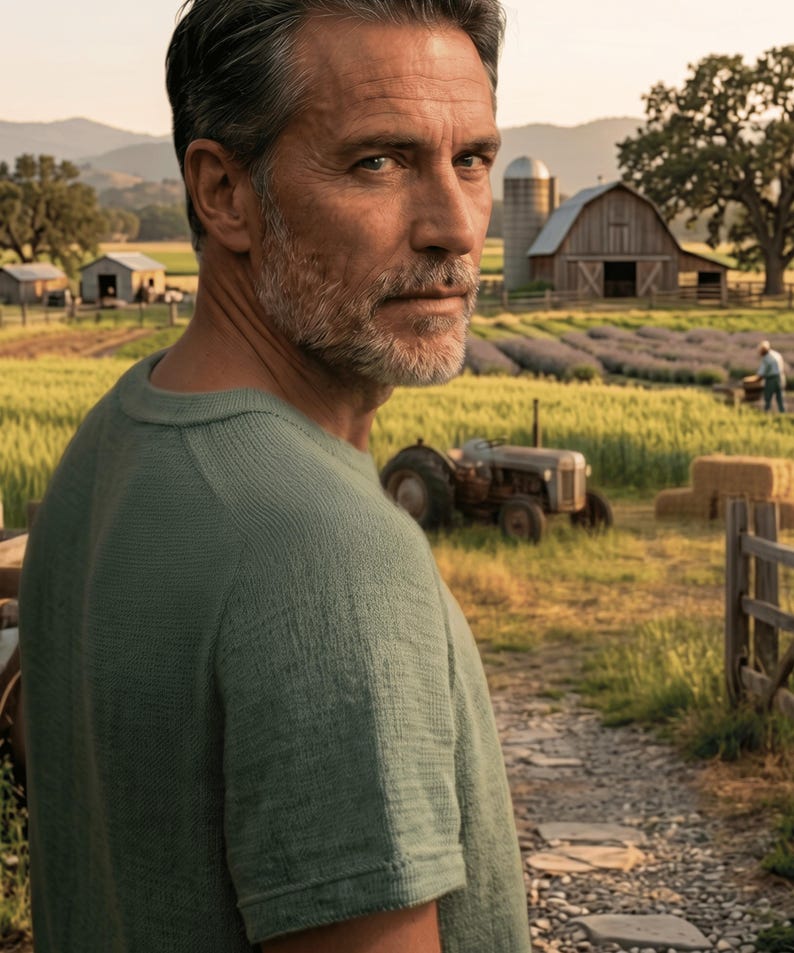 Puede incluir: Un hombre con una camisa verde mira por encima del hombro. El fondo muestra una granja con un granero, campos y un tractor. La escena est&aacute; ba&ntilde;ada por la c&aacute;lida luz del sol, lo que sugiere un entorno rural.