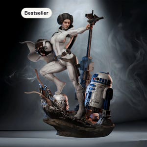 Puede incluir: Estatua detallada de un personaje con un atuendo blanco, sosteniendo un bláster y un casco, con R2-D2 y una estructura mecánica. La estatua está sobre una base rocosa. La palabra "Bestseller" está en un óvalo blanco.