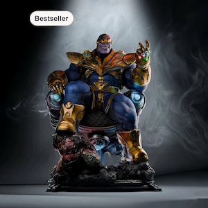 May include: A detailed statue of Thanos, seated on a throne. The figure is predominantly blue and gold, with a purple face and the Infinity Gauntlet. The statue is on a black base, with the word "Bestseller" in a white oval.