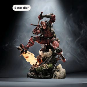 May include: A detailed figurine of Deadpool in a dynamic action pose, wielding swords and a gun. The figure is predominantly red and black, with intricate detailing on the costume and base. The word "Bestseller" is in a white oval in the top left corner.
