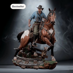 Può includere: Statua dettagliata di un cowboy a cavallo. Il cowboy indossa una camicia blu, un cappello e tiene una pistola. Il cavallo è marrone e bianco. La base include un cartello Wanted e binari ferroviari. La parola "Bestseller" è in alto a sinistra.