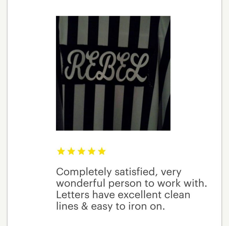 May include: A black and white striped iron-on patch with the word "REBEL" in white cursive lettering.