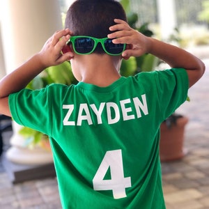 以下が含まれることがあります： 背中に「ZAYDEN」という名前と「4」という番号が印刷された緑色のサッカーユニフォームです。