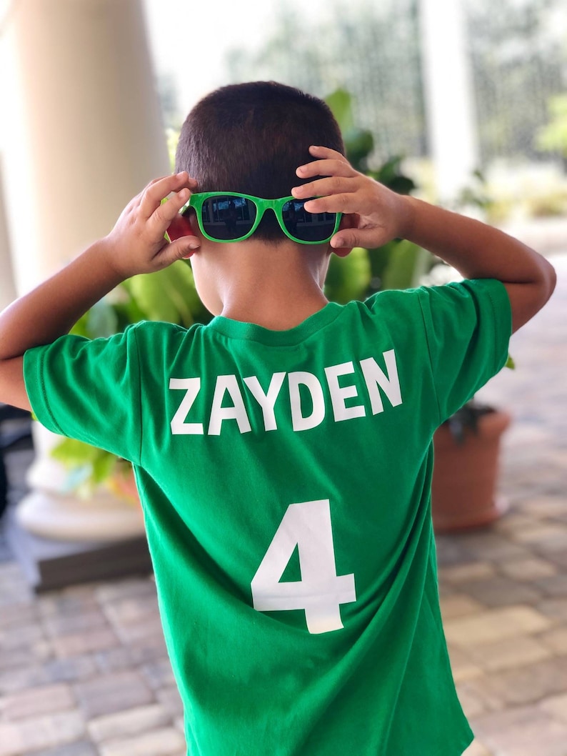 以下が含まれることがあります： 背中に「ZAYDEN」という名前と「4」という番号が印刷された緑色のサッカーユニフォームです。
