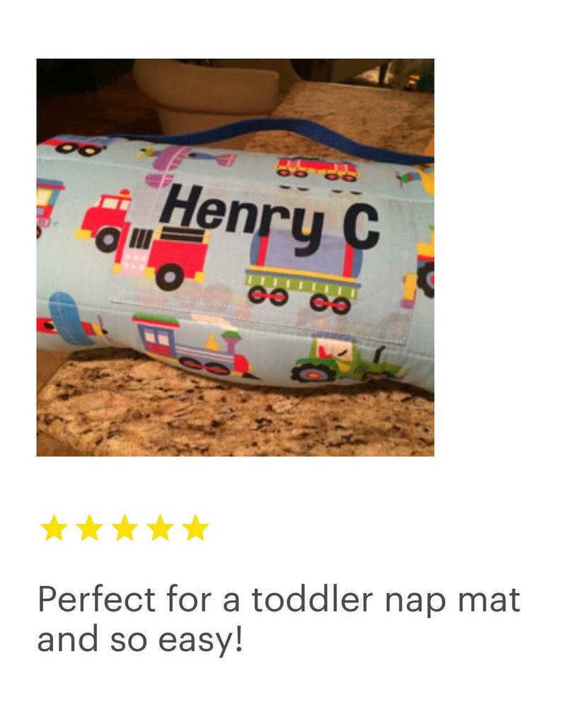 May include: A blue and white nap mat with a colorful train and truck design. The mat has a personalized name tag that reads "Henry C".