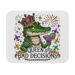 以下が含まれることがあります： 王冠をかぶりカクテルを持つ漫画のアリゲーターが描かれた白い正方形のコースター。アリゲーターは緑色で、ビーズのネックレスをしています。「QUEEN OF BAD DECISIONS」の文字が金色のグリッターで書かれています。