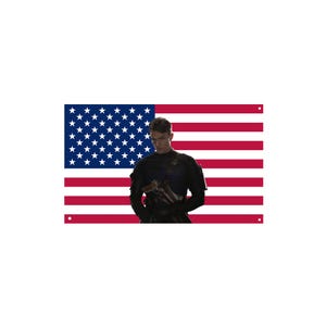 May include: A person in a black uniform stands in front of an American flag. The flag has red and white stripes and a blue field with white stars. The person is holding a gun.