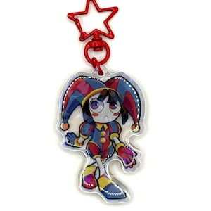 May include: A colorful keychain featuring a cartoon jester character. The jester wears a blue, red, and yellow outfit with a matching hat. The keychain has a red star-shaped clasp.