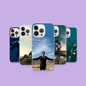 Puede incluir: Cinco fundas para teléfono con diferentes imágenes, incluyendo un hombre en traje con los brazos extendidos y escenas de acción. Las fundas están dispuestas en fila sobre un fondo morado. Las fundas son para un teléfono móvil.