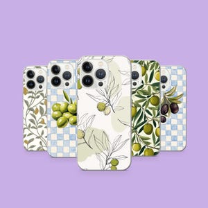 Op de afbeelding: Een verzameling telefoonhoesjes met olijftak- en olijffruitontwerpen. De hoesjes hebben verschillende patronen, waaronder aquarel illustraties van olijven, bladeren en geblokte achtergronden in groen, wit en blauw. Op een lichtpaarse achtergrond.