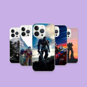 Op de afbeelding: Een verzameling van vijf telefoonhoesjes met afbeeldingen van robots in verschillende actieposes. De hoesjes tonen levendige kleuren, waaronder blauw, rood en oranje, tegen achtergronden van landschappen en luchten. De hoesjes zijn geplaatst op een lichtpaarse achtergrond.