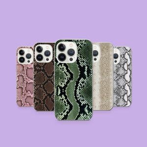Può includere: Cinque custodie per smartphone con motivo a pelle di serpente nei toni del rosa, marrone, verde, beige e grigio. Le custodie hanno una finitura lucida e sono esposte su uno sfondo viola.