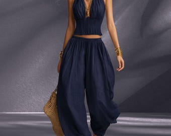 Conjunto feminino com top cropped de alças no pescoço e costas nuas e calça pantalona, ideal para o verão e resorts.