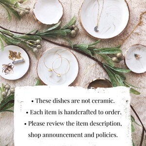 May include: White and gold-rimmed decorative dishes with jewelry, including a necklace with a crescent moon pendant and gold hoop earrings. Greenery and text are also visible. The text says: These dishes are not ceramic. Each item is handcrafted to order. Please review the item description, shop announcement and policies.