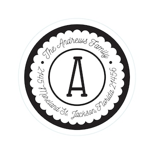 Puede incluir: Una etiqueta de dirección redonda, en blanco y negro, con un borde festoneado. La etiqueta presenta el texto "The Andrews Family" en escritura cursiva, la dirección "2445 Moreland St. Jackson, Florida 21456" y una letra "A" grande.