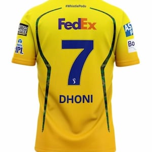 Op de afbeelding: Geel cricketshirt met groene accenten, met het blauwe nummer 7, de naam DHONI en het FedEx-logo. Het shirt heeft ook de tekst "#WhistlePodu" en logo's voor British Empire en Tata IPL.