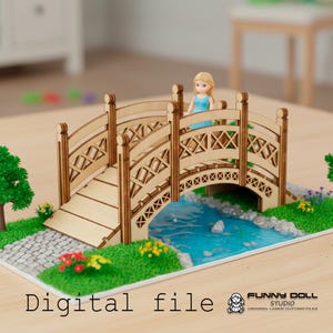 Op de afbeelding: Een miniatuur houten brug met ingewikkelde traliewerkdetails, over een blauwe rivier. Een kleine pop in een blauwe jurk staat op de brug. De scène bevat groen gras, bloemen en de tekst "Digital file".