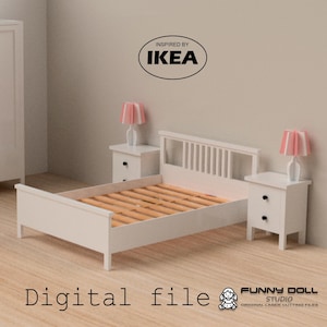 Op de afbeelding: Een wit poppenbed met een lattenbodem en voeteneinde, geflankeerd door twee bijpassende nachtkastjes. Elk nachtkastje heeft een lamp met een roze lampenkap. De afbeelding bevat de tekst "Digital file" en "Inspired by IKEA".